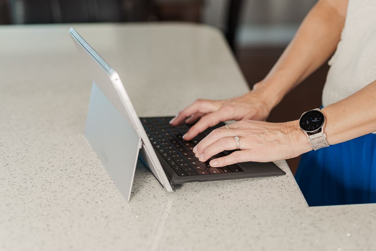 Photo of woman typing on a laptop.