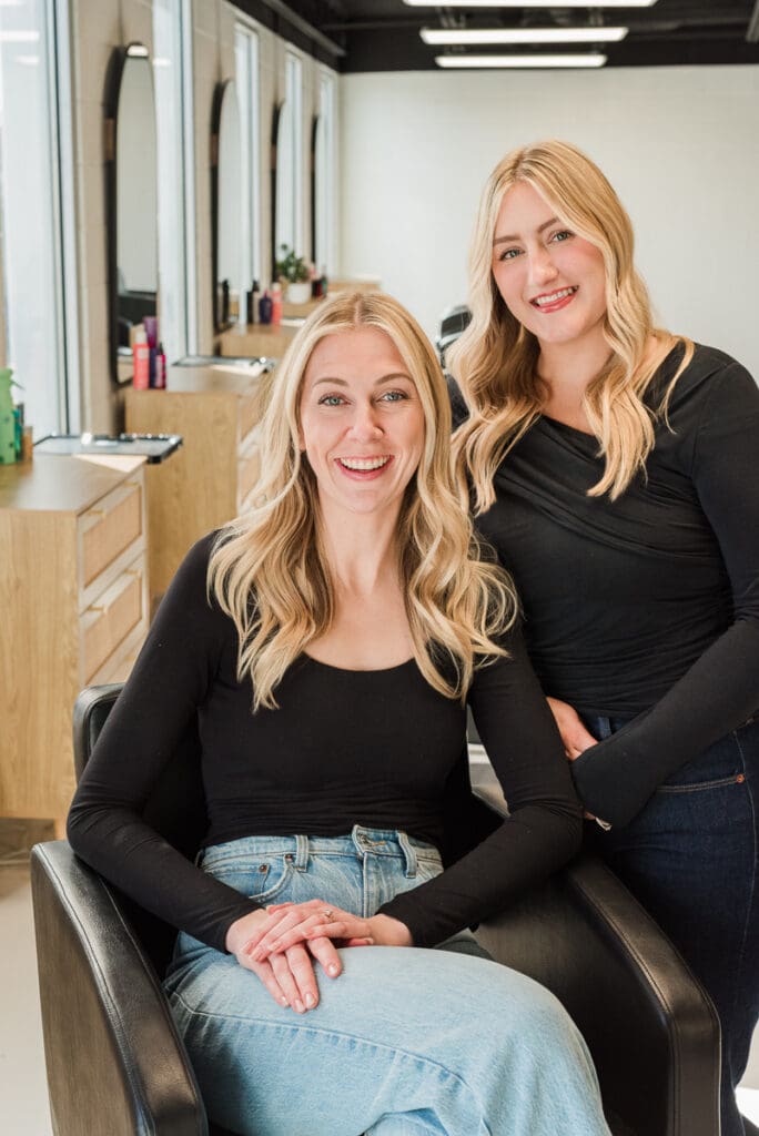 Custom brand photo for website of salon owners smiling in new salon space.