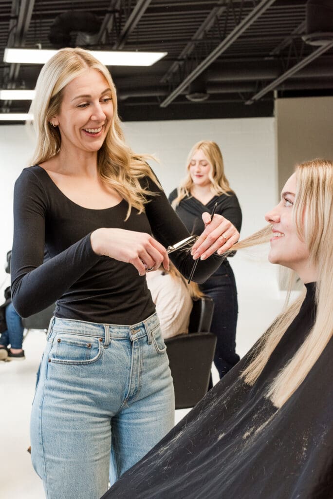 Visual trust factor in action: salon owners confidently interacting with client in bright, modern brand photo.